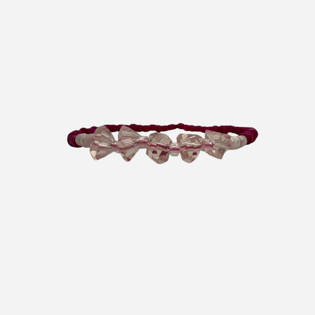 SPARQ pink seed bead stretch bracelet with clear crystal bow charms. Elastic design for comfortable wear.