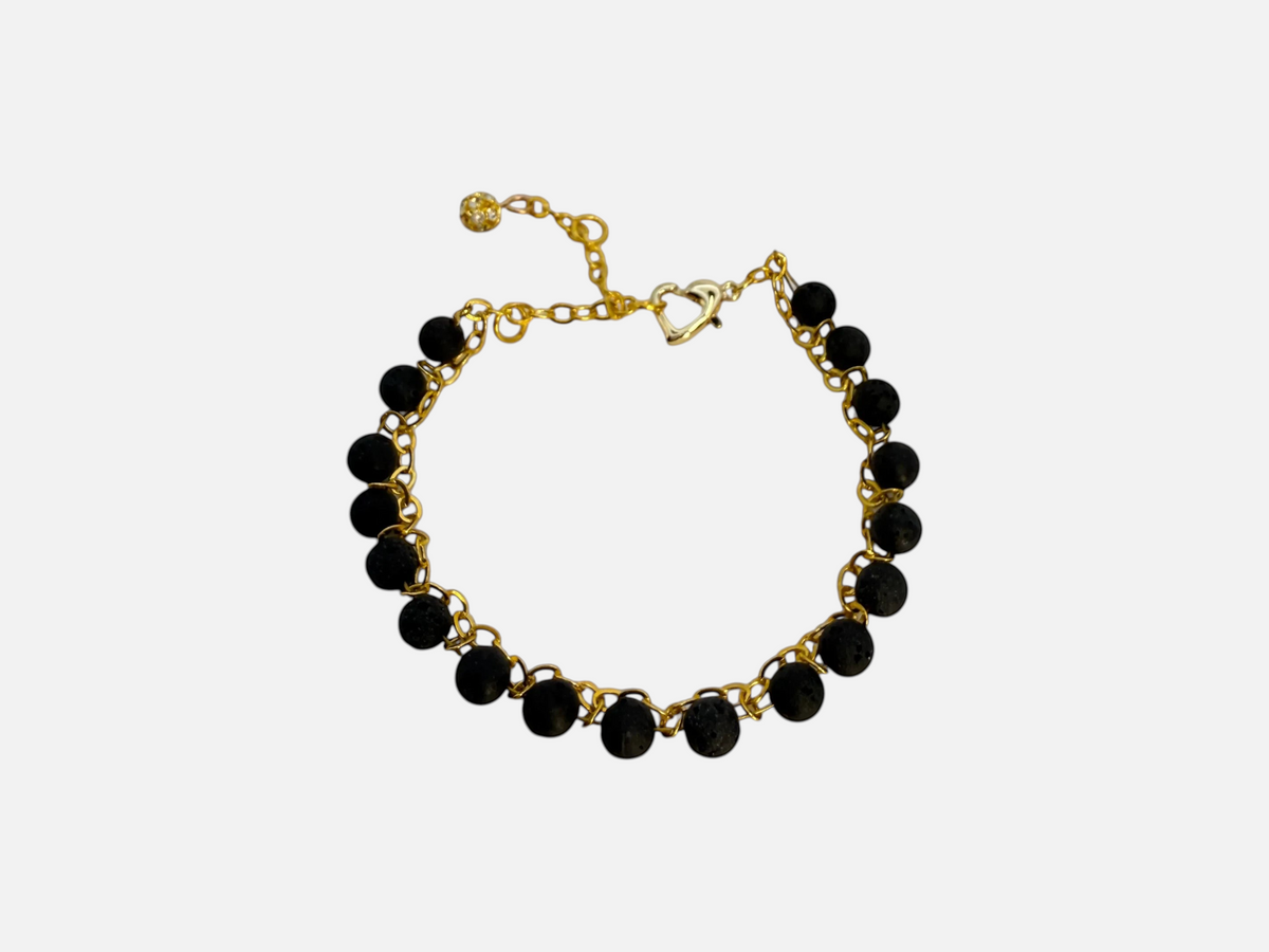 SPARQ armband met zwarte lavastenen en goudkleurige schakelketting, voorzien van hartvormige sluiting en bedeltje.