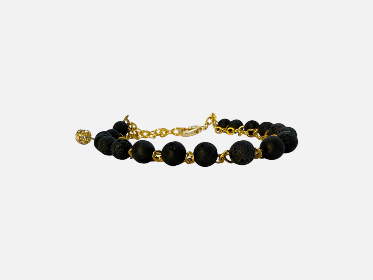 SPARQ armband met zwarte lavastenen en goudkleurige schakelketting, voorzien van een sprankelend bedeltje.