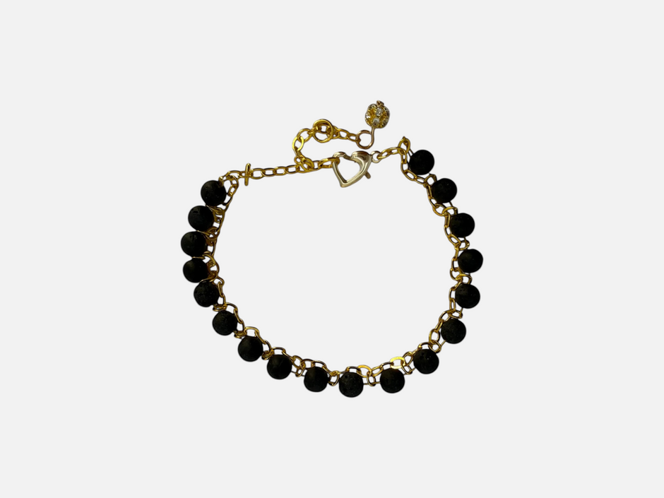 SPARQ armband met zwarte lavastenen en goudkleurige schakelketting, voorzien van een hartvormige sluiting en bedel.