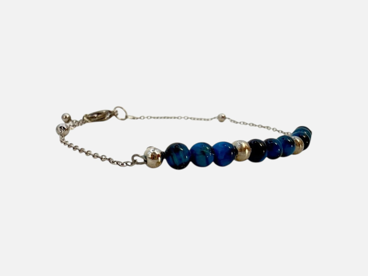 SPARQ Blue Tide armband met blauwe kralen en een verfijnde zilverkleurige ketting, verstelbaar en waterbestendig.