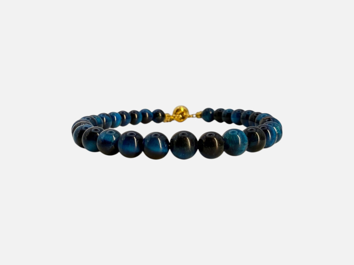 SPARQ verstelbare kralenarmband van blauwe tijgeroog met luxe goudkleurige details op een witte achtergrond.