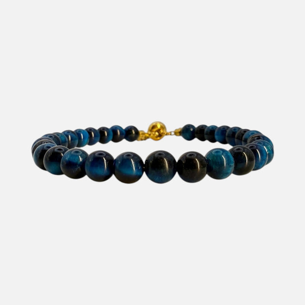 SPARQ verstelbare kralenarmband van blauwe tijgeroog met luxe goudkleurige details op een witte achtergrond.
