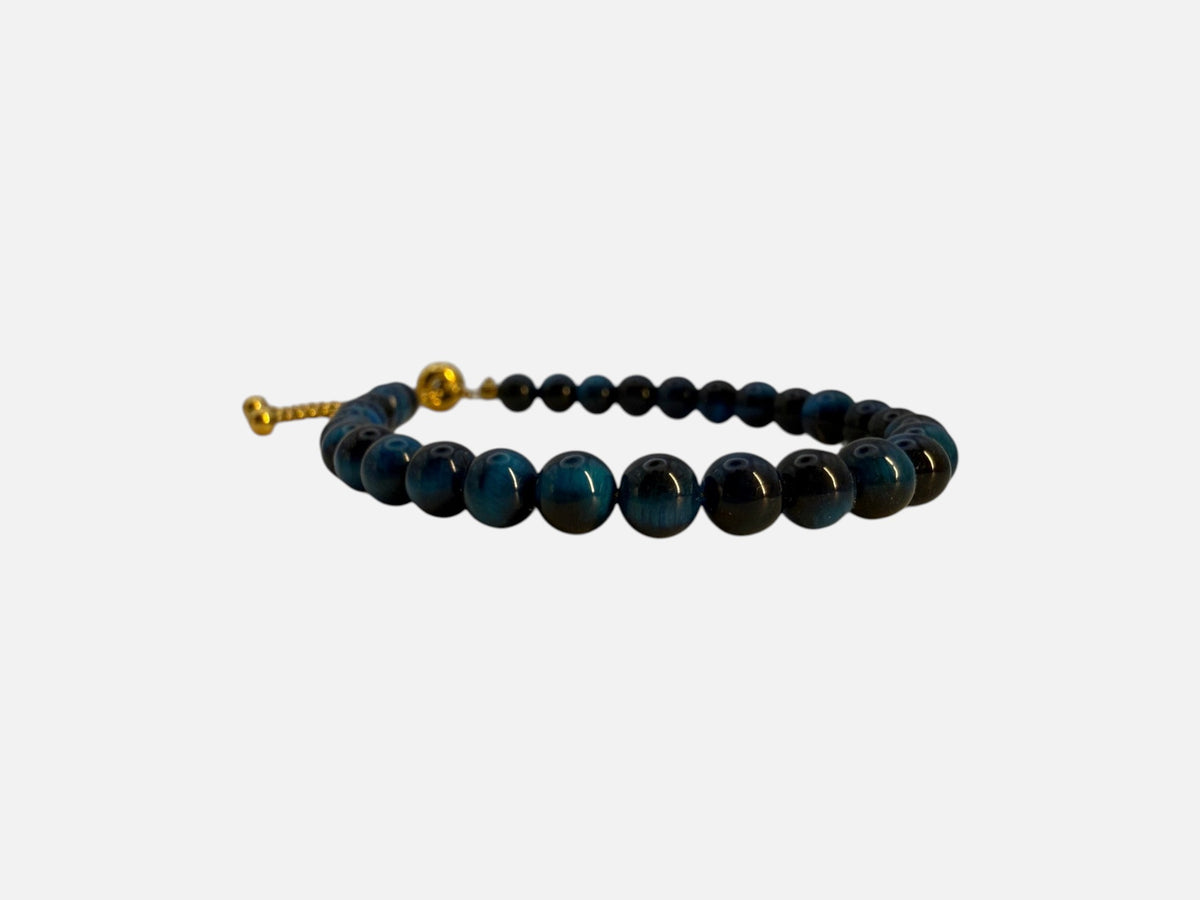 SPARQ verstelbare kralenarmband van blauwe tijgeroog met luxe goudkleurige details op een witte achtergrond.