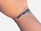 SPARQ Blue Tide armband met blauwe kralen en een verfijnde zilverkleurige ketting om een pols.