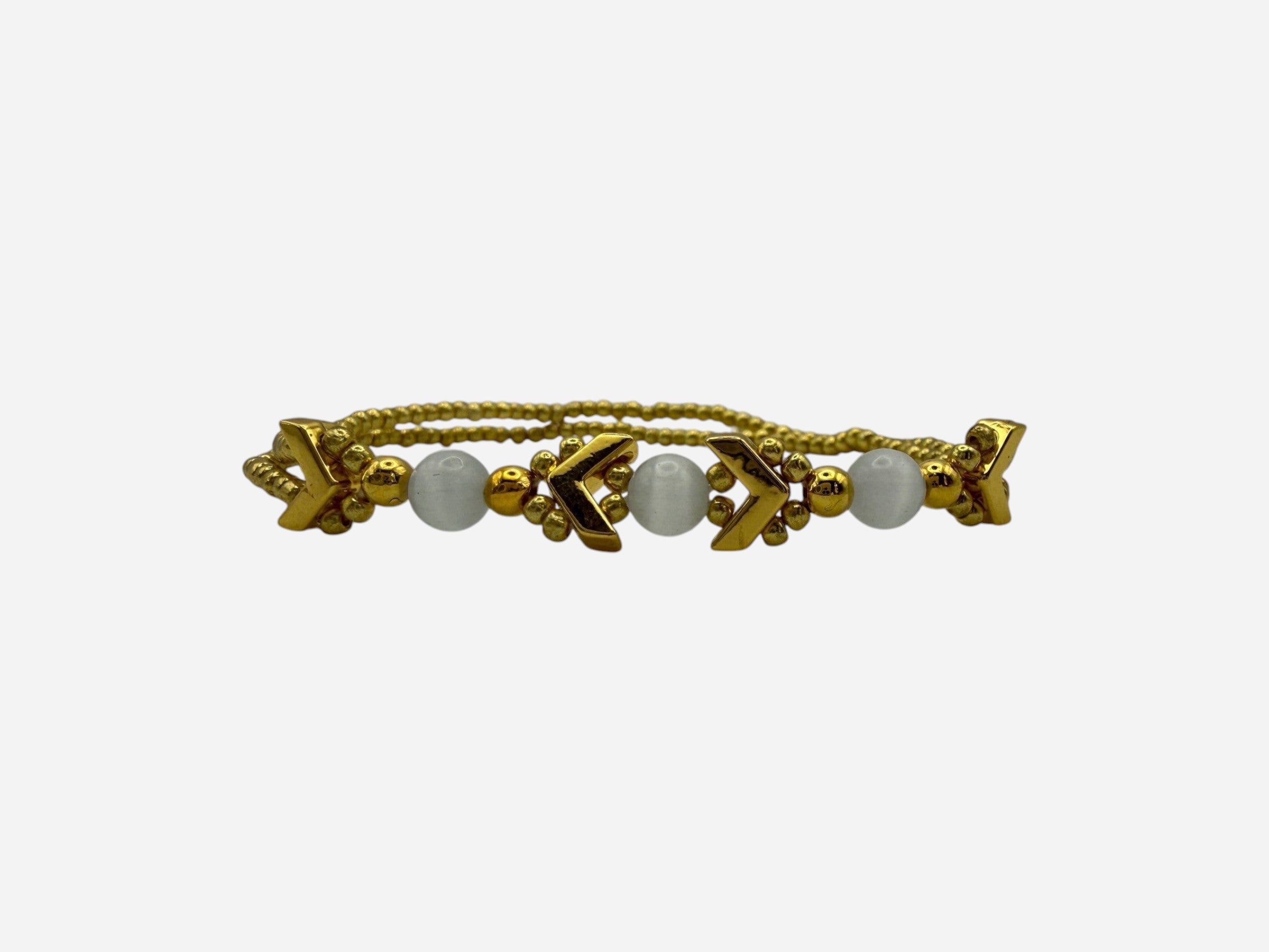 SPARQ gold-tone double strand bracelet with white beads and chevron accents.