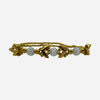 SPARQ gold-tone double strand bracelet with white beads and chevron accents.