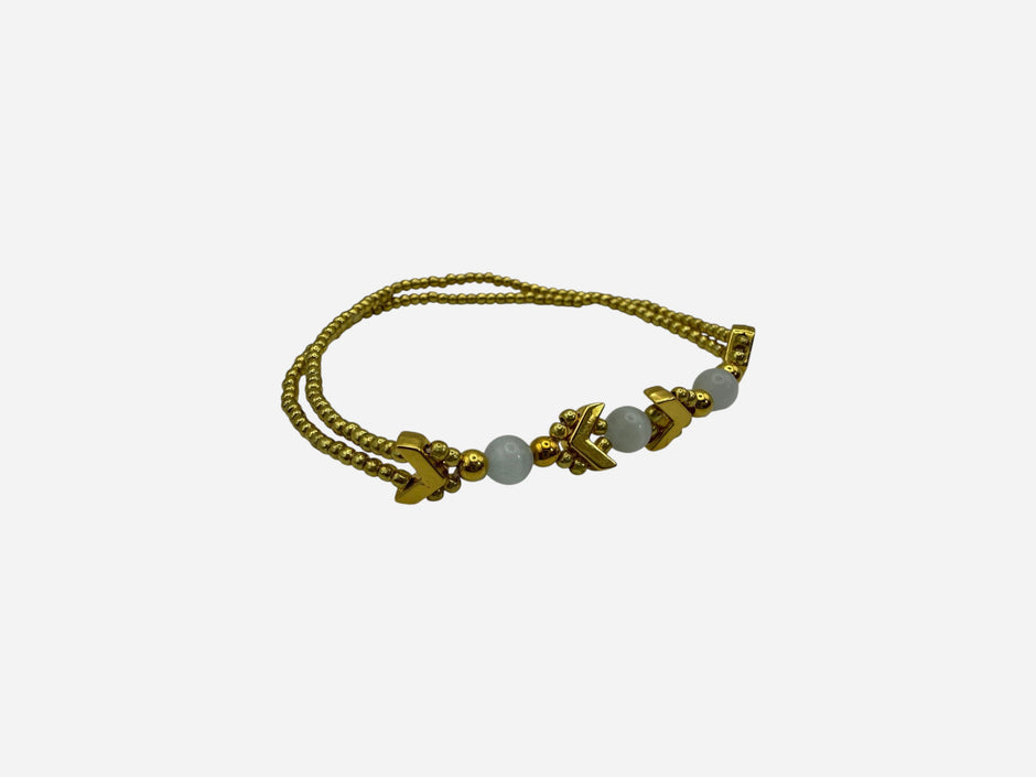 SPARQ double strand gold-tone bracelet with white beads and chevron accents.