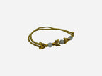 SPARQ double strand gold-tone bracelet with white beads and chevron accents.