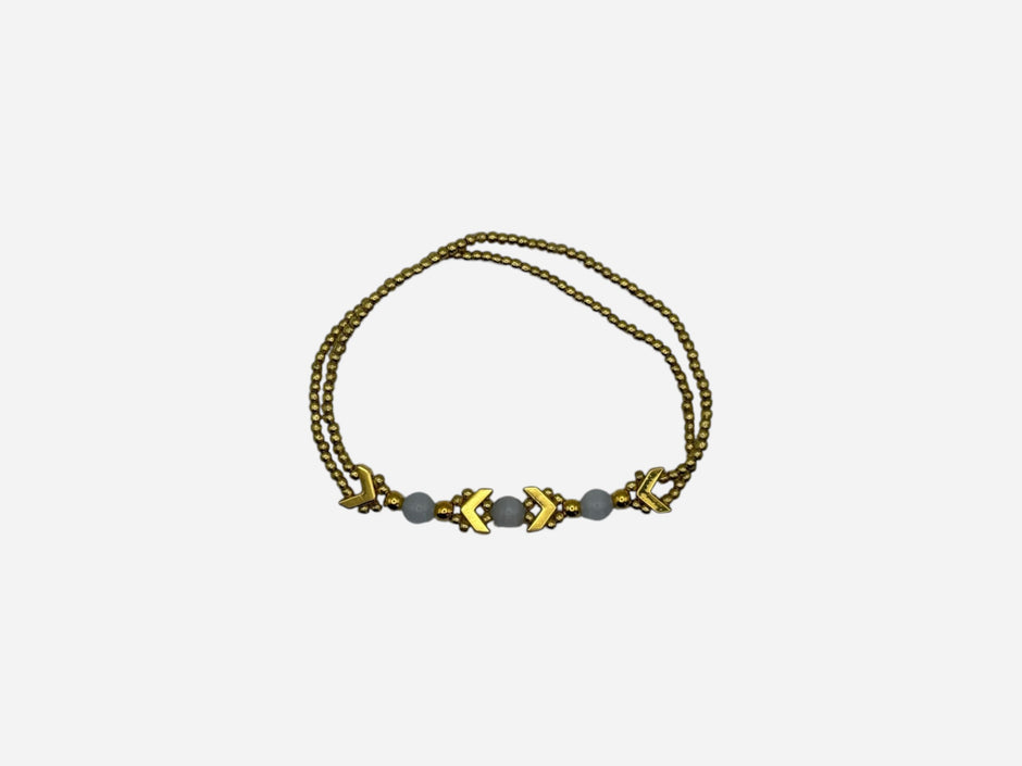 SPARQ gold-tone double strand bracelet with white beads and chevron accents.