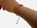 SPARQ armband met goudkleurige schakelketting en oranje edelsteenkralen om een pols