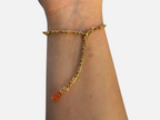 SPARQ armband met goudkleurige schakelketting en oranje edelsteenkraal aan een verstelbare sluiting om een pols