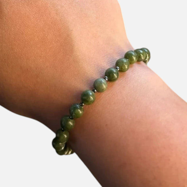 SPARQ handgemaakte kralenarmband van groene edelstenen om een pols, met een minimalistisch en elastisch ontwerp.