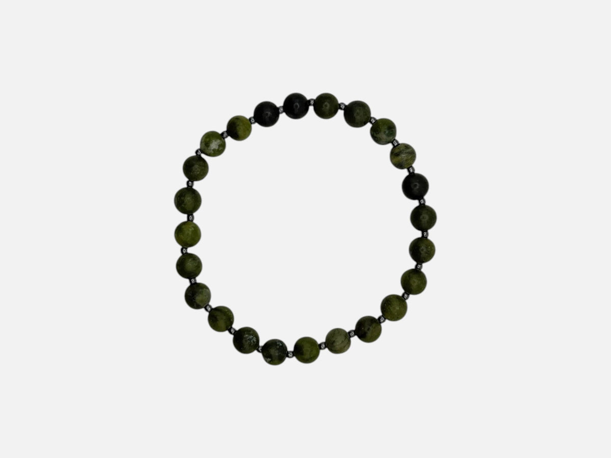SPARQ handgemaakte kralenarmband met groene edelstenen en donkere accentkralen op een witte achtergrond
