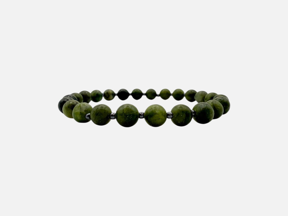 SPARQ handgemaakte kralenarmband van groene edelstenen met donkere tussenkralen op een witte achtergrond