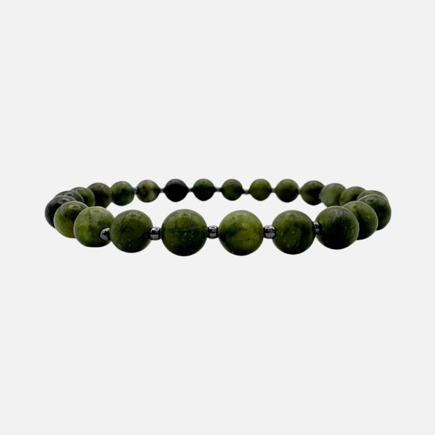 SPARQ handgemaakte kralenarmband van groene edelstenen met donkere tussenkralen op een witte achtergrond