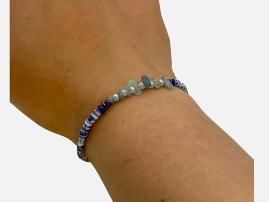 SPARQ handgemaakte kralenarmband met blauw-witte kralen en natuurlijke edelsteenfragmenten om een pols.
