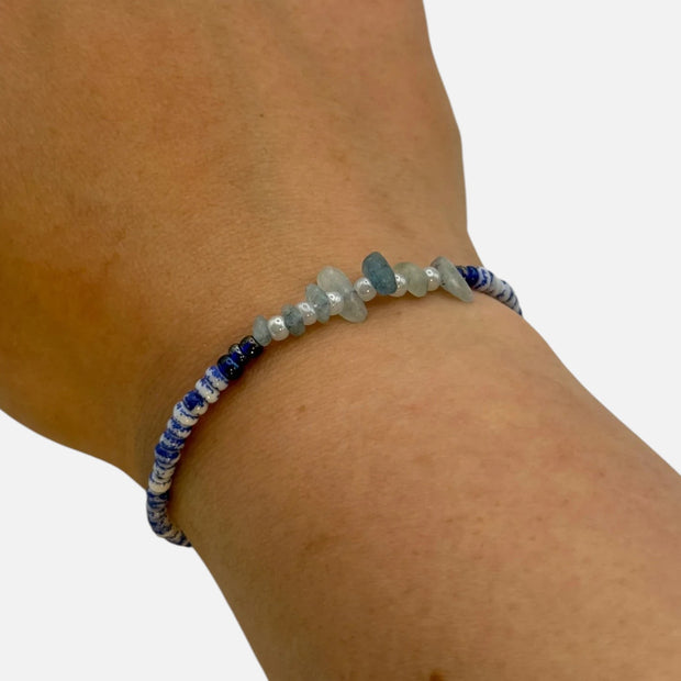 SPARQ handgemaakte kralenarmband met blauw-witte kralen en natuurlijke edelsteenfragmenten om een pols.