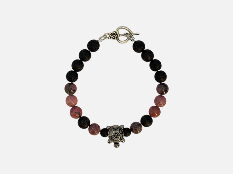 SPARQ kralenarmband met zwarte lavastenen, roze rhodoniet en een zilverkleurige schildpadbedel op witte achtergrond.