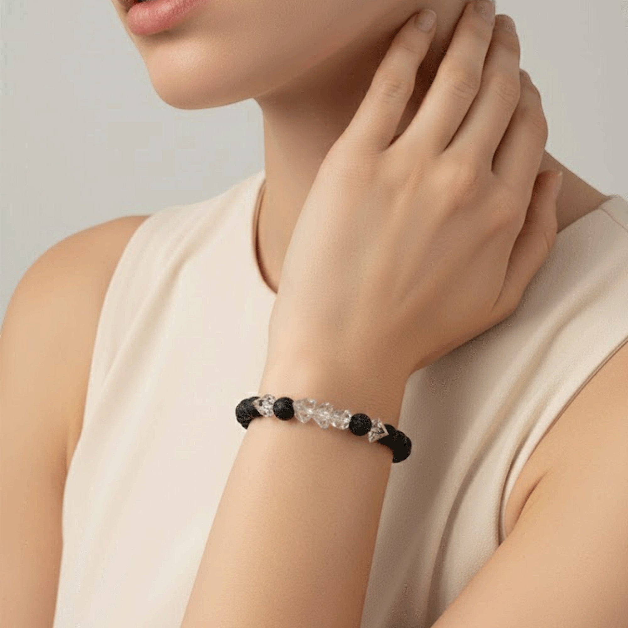 SPARQ black lava stone bracelet with clear crystal accents on a woman's wrist.
