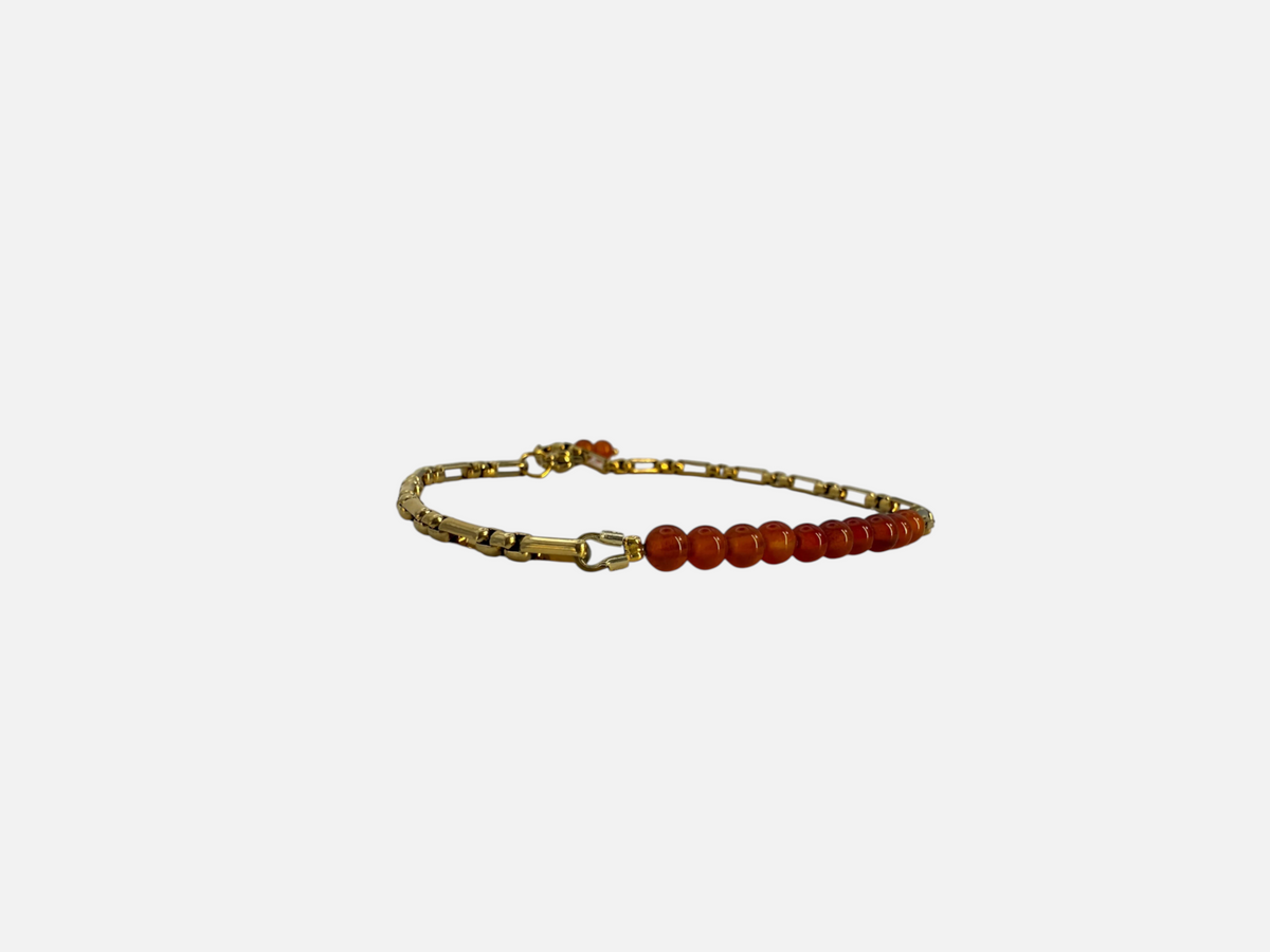 SPARQ armband met oranje edelsteenkralen en een verfijnde goudkleurige schakelketting op een witte achtergrond.