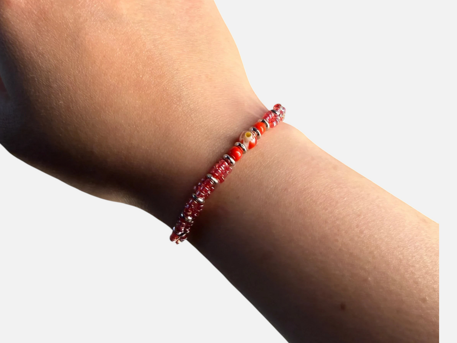 SPARQ verstelbare armband met rode kralen en bloemmotief gedragen om een pols