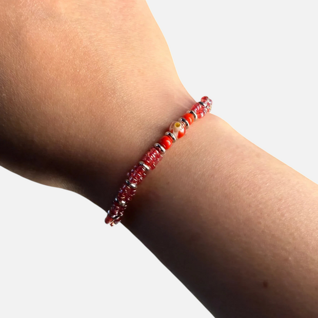 SPARQ verstelbare armband met rode kralen en bloemmotief gedragen om een pols
