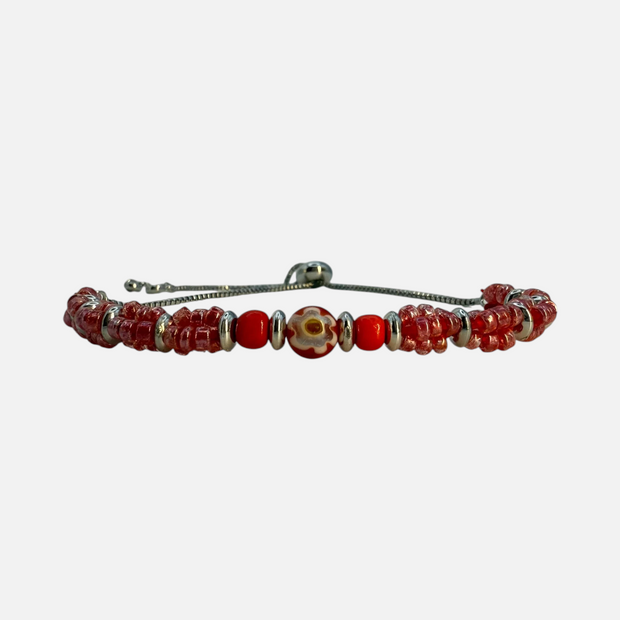 SPARQ verstelbare armband met rode kralen, zilverkleurige accenten en een unieke bloemenkraal in het midden.