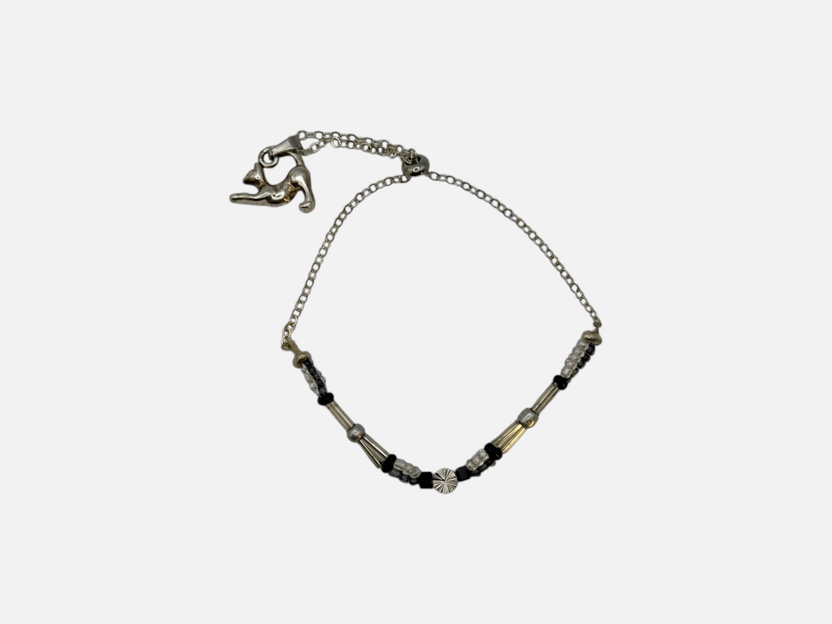 SPARQ zilverkleurige armband met kattenhanger, zwarte en transparante kralen en een verfijnde schakelketting.
