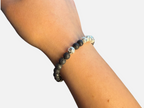 SPARQ kralenarmband met zwarte lavastenen en glanzende zilverkleurige accenten om een pols
